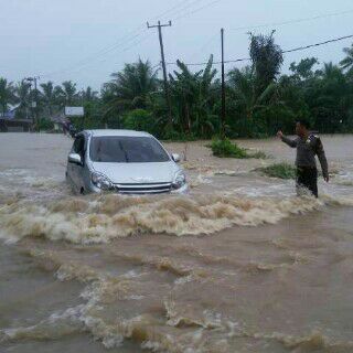 Bhabinkamtibmas Atur Lalin di Jalan Tergenang Banjir