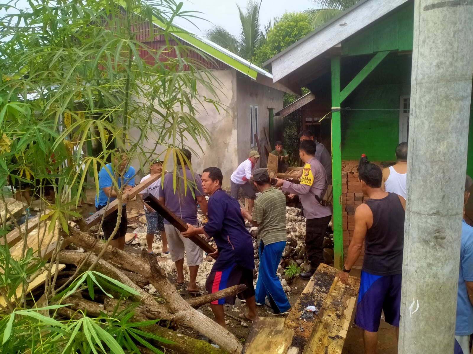 Bersama Warga, Bhabinkamtibmas Gotong Royong Membersihkan Lokasi Kebakaran Rumah